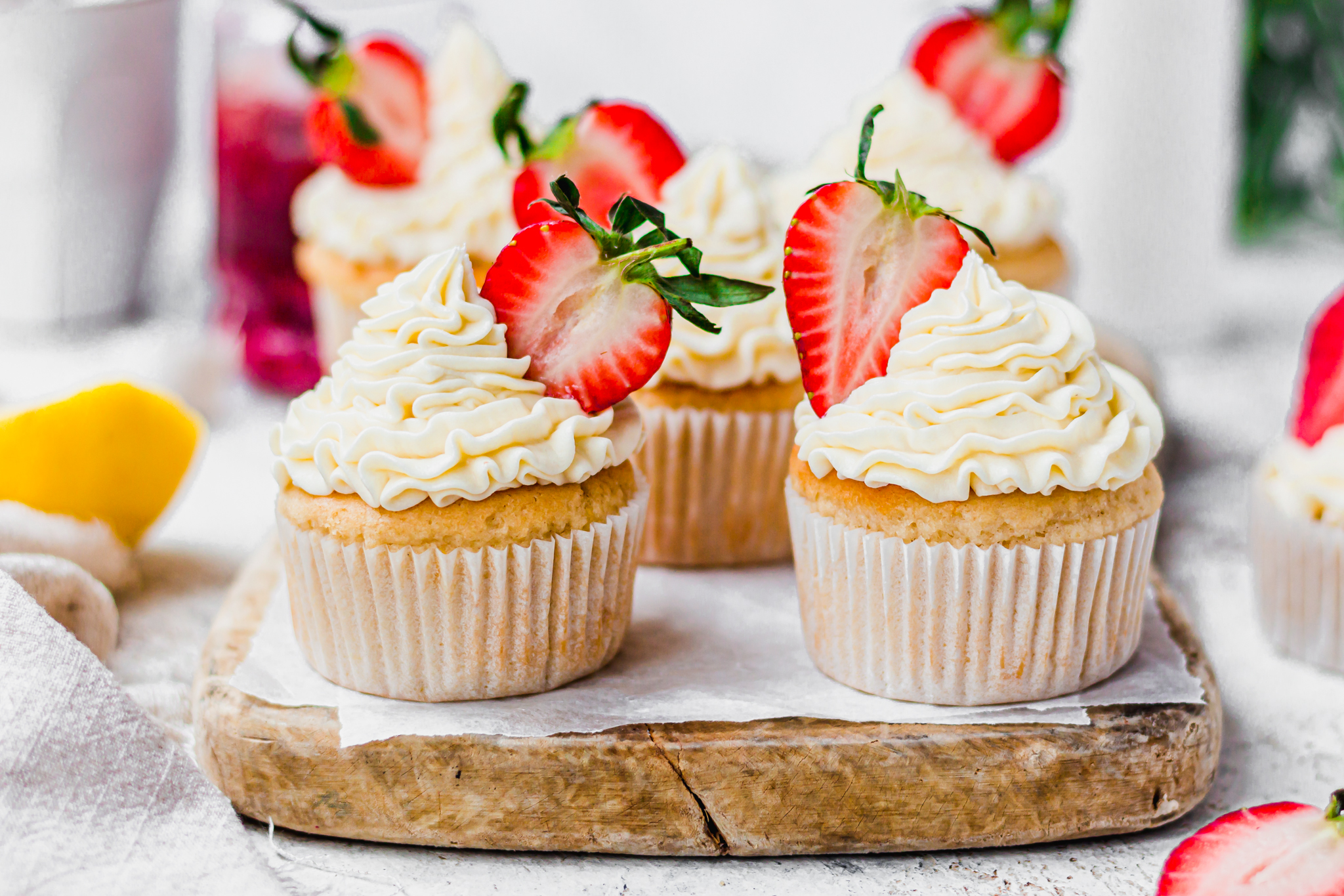 Two Vegan Lemon Strawberry Cupcakes on a wooden board