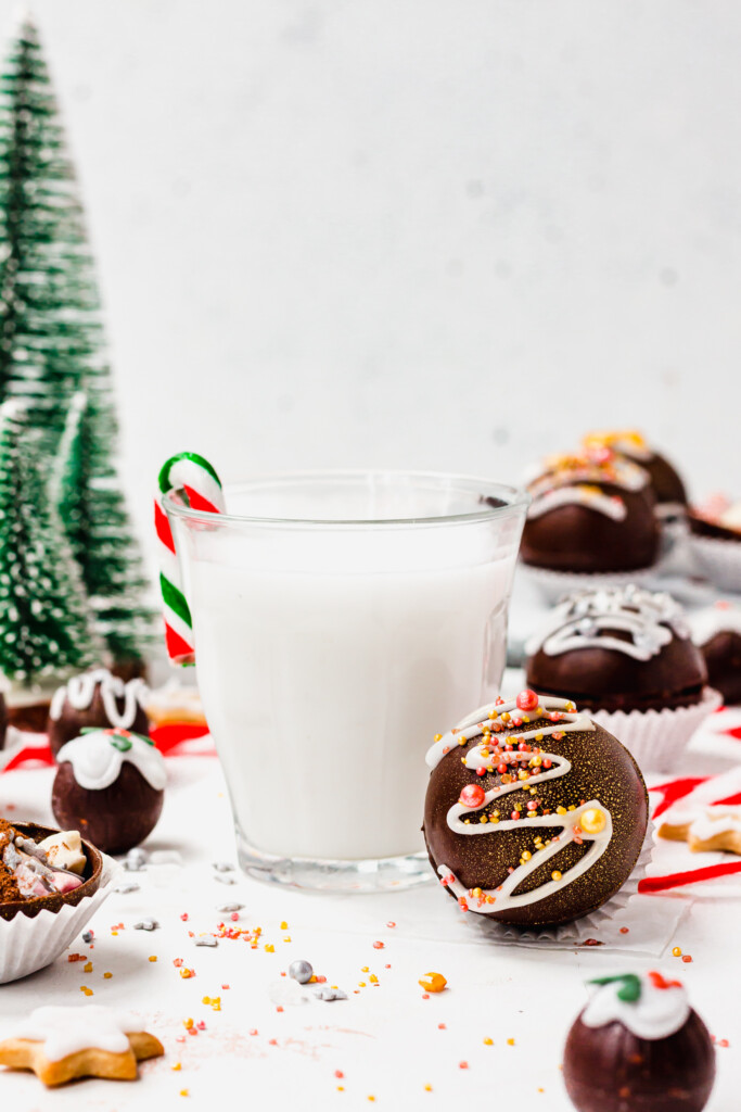 An Easy Vegan Hot Chocolate Bomb in front of a glass of milk