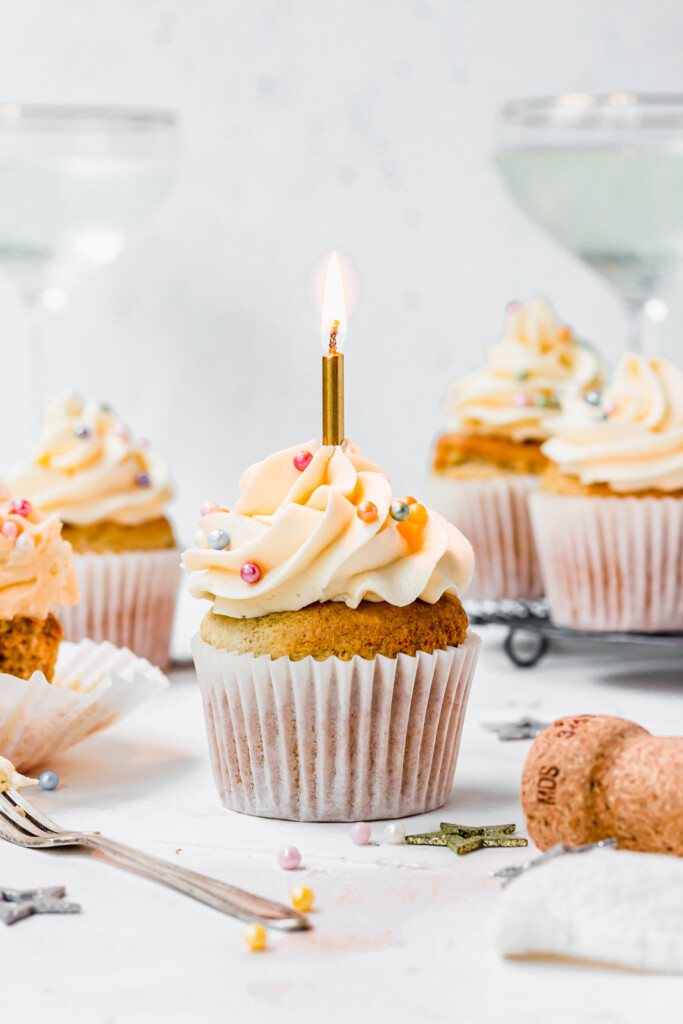 Vegan Champagne Cupcakes with White Chocolate Buttercream with a lit up candle