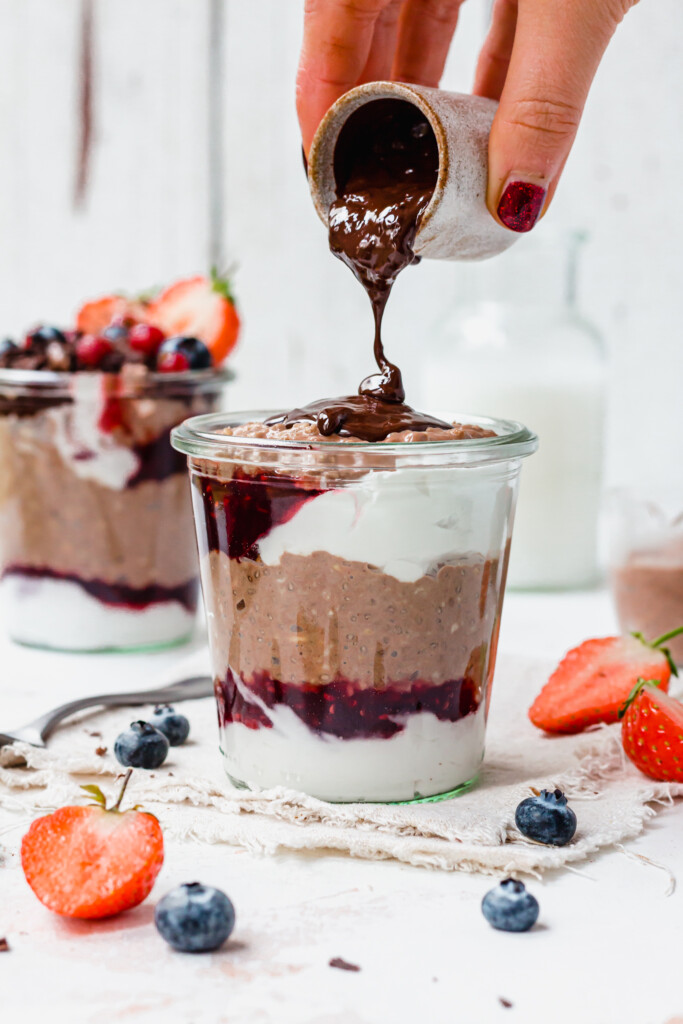 Pouring chocolate over Chocolate Berry Overnight Oats
