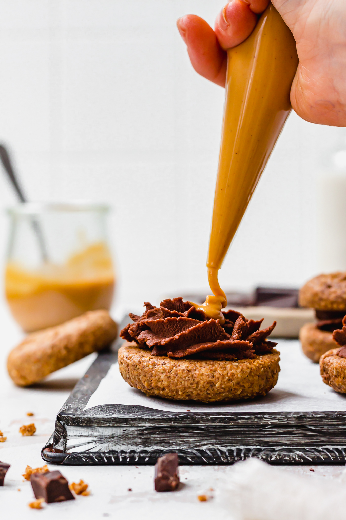 Piping peanut butter into Chocolate Filled Peanut Butter Cookie Sandwiches