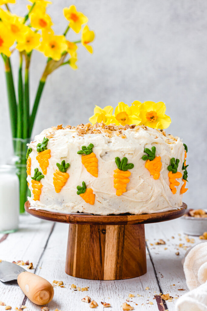 Vegan Carrot Cake with Orange Buttercream on a wooden cake stand