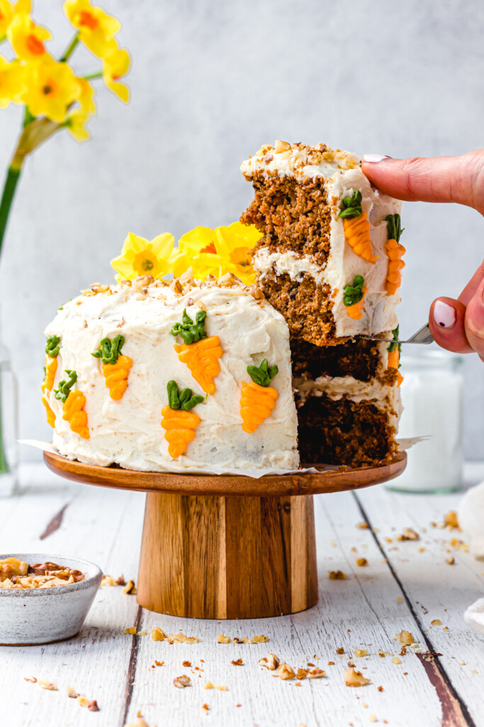 Lifting out a slice of Vegan Carrot Cake with Orange Buttercream