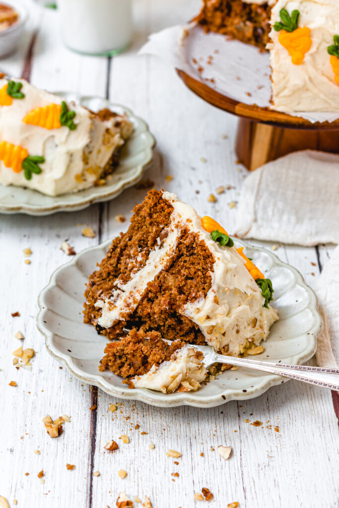 A fork into a slice of Vegan Carrot Cake with Orange Buttercream