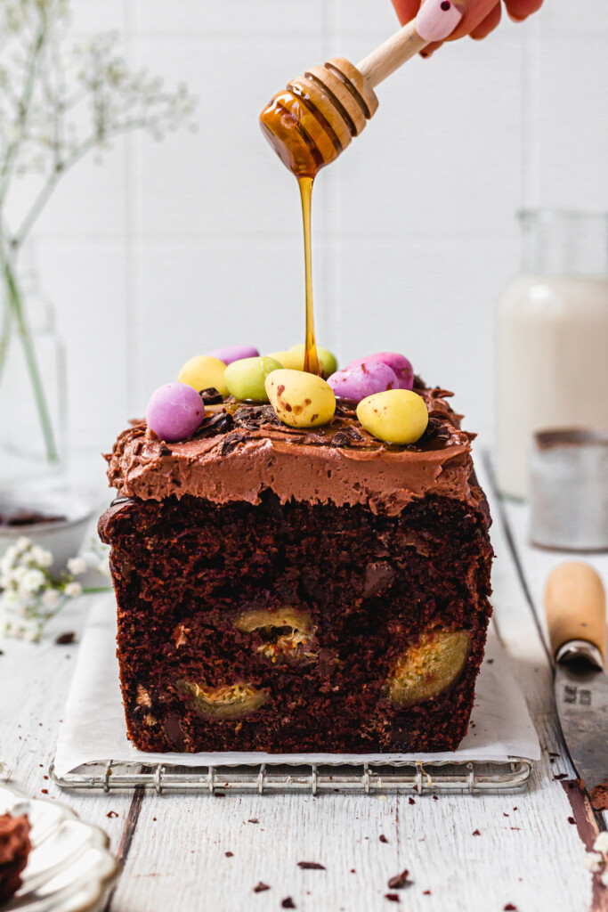 Drizzling syrup over Vegan Double Chocolate Fig Loaf Cake