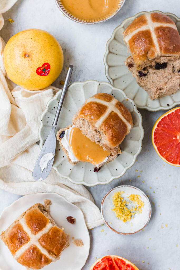 Easy Vegan Hot Cross Buns on plates with grapefruits