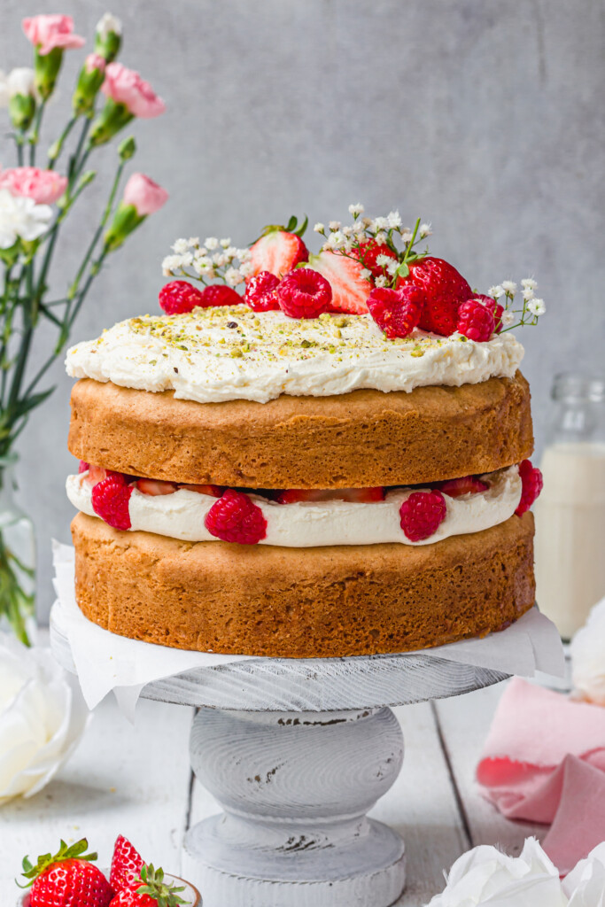 Gluten-Free Vegan Victoria Sponge Cake on a white cake stanc