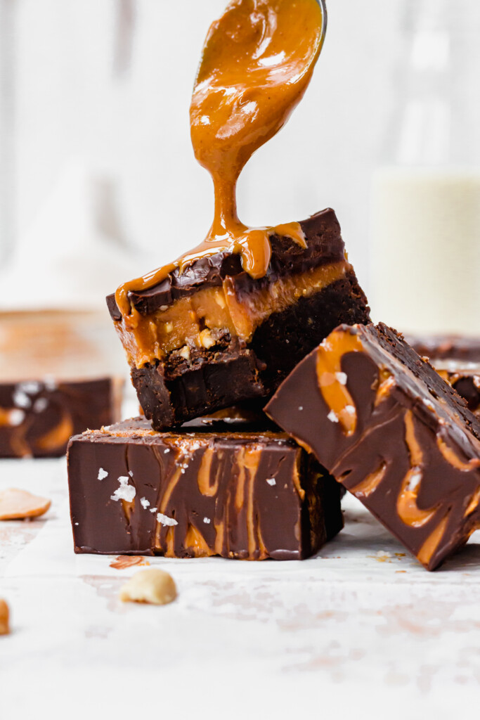Drizzling peanut butter over Snickers Caramel Brownies