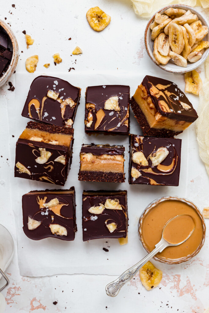 Chocolate Peanut Butter Banana Caramel Squares with a pot of peanut butter