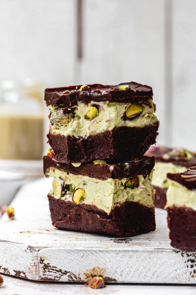 Two Pistachio Ice Cream Brownie Slices on a wooden board