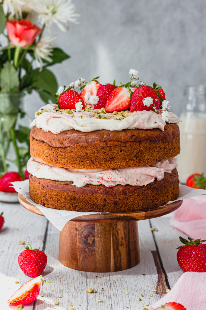 Strawberries and Cream Banana Bread on a wooden cake stand