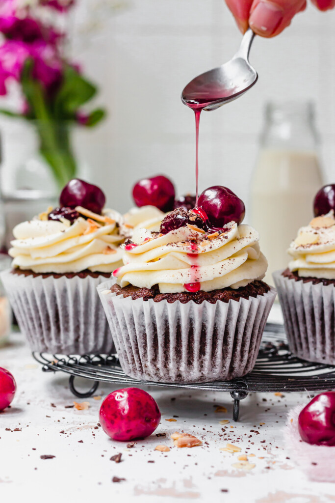 Drizzling syrup over Chocolate Cherry Amaretto Cupcakes