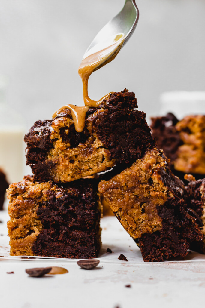 Drizzling hazelnut butter over Chocolate Chip Cookie Brownie Bars