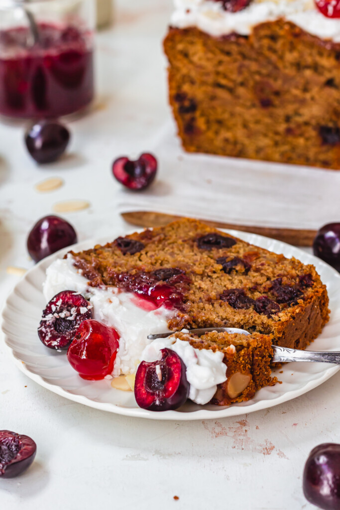 A slice of Cherry Bakewell Banana Bread on a plate with a fork