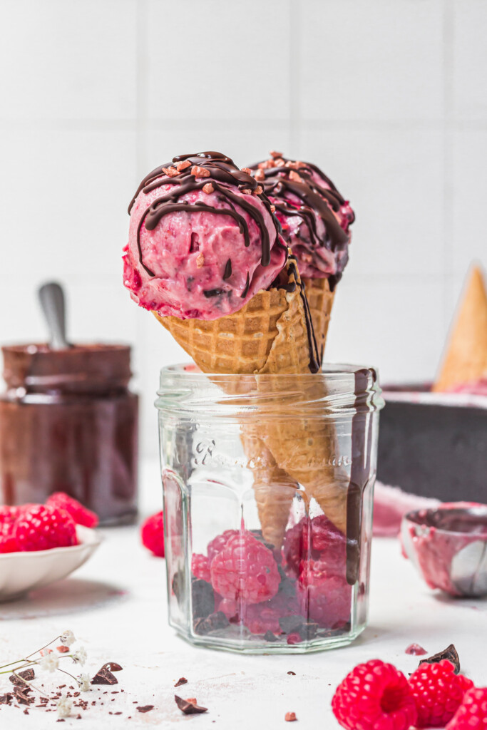 Two cones of Chocolate Chunk Raspberry Ice Cream in a jar