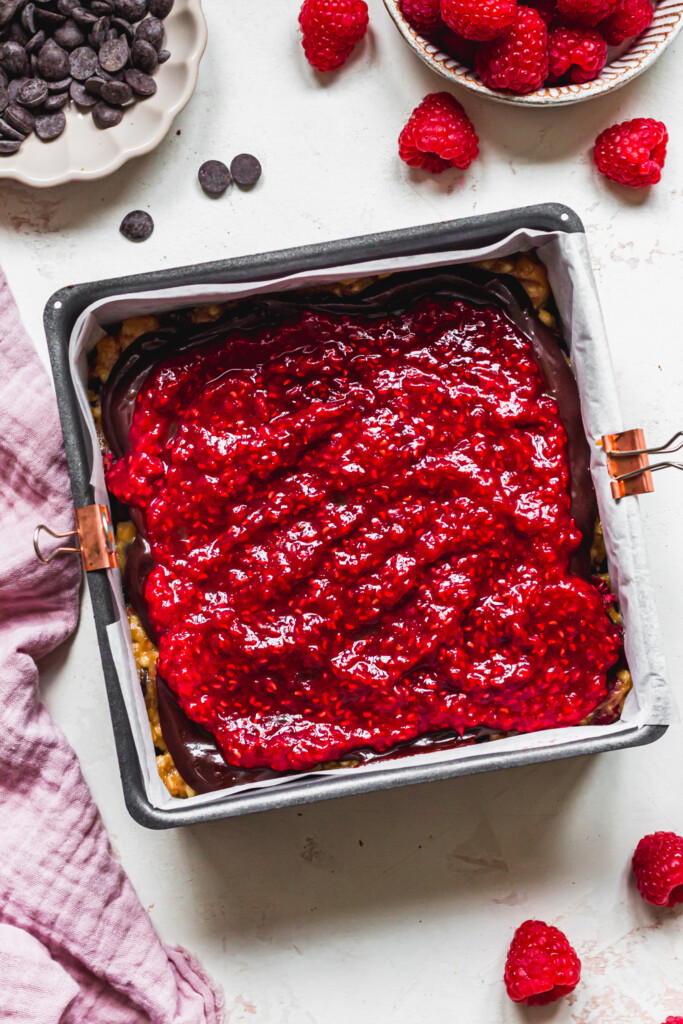 A tin of bars topped with raspberry compote