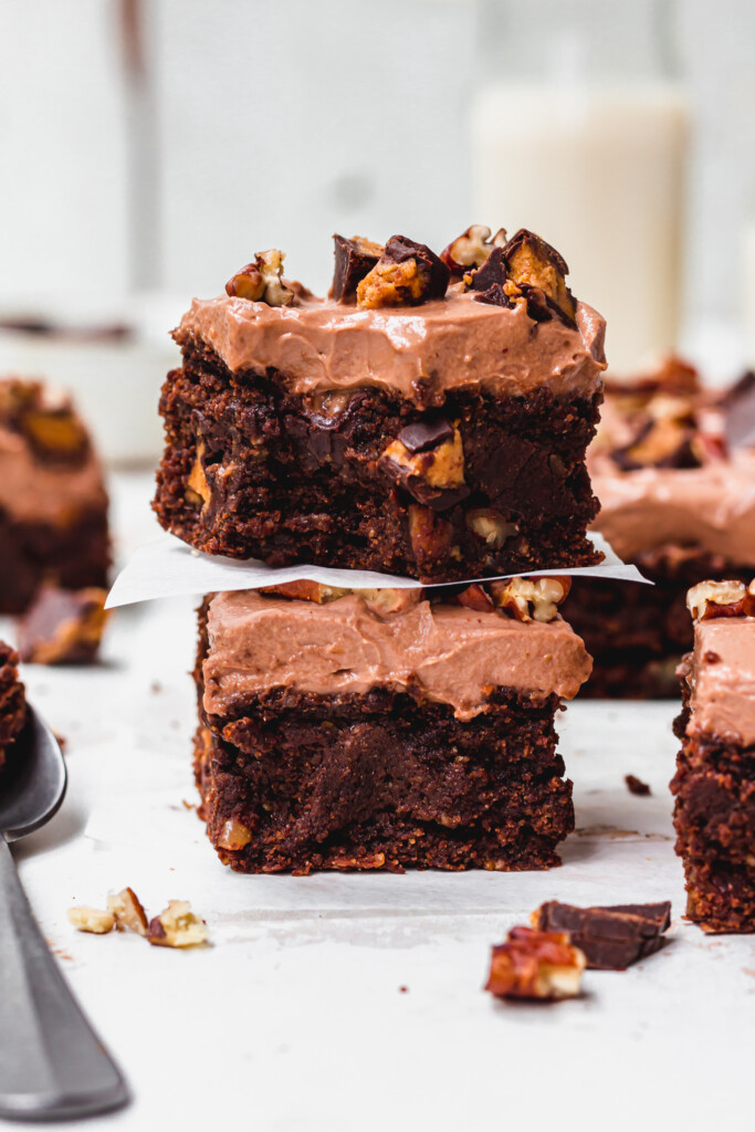 A stack of two pieces of Pecan Peanut Butter Cup Frosted Brownies