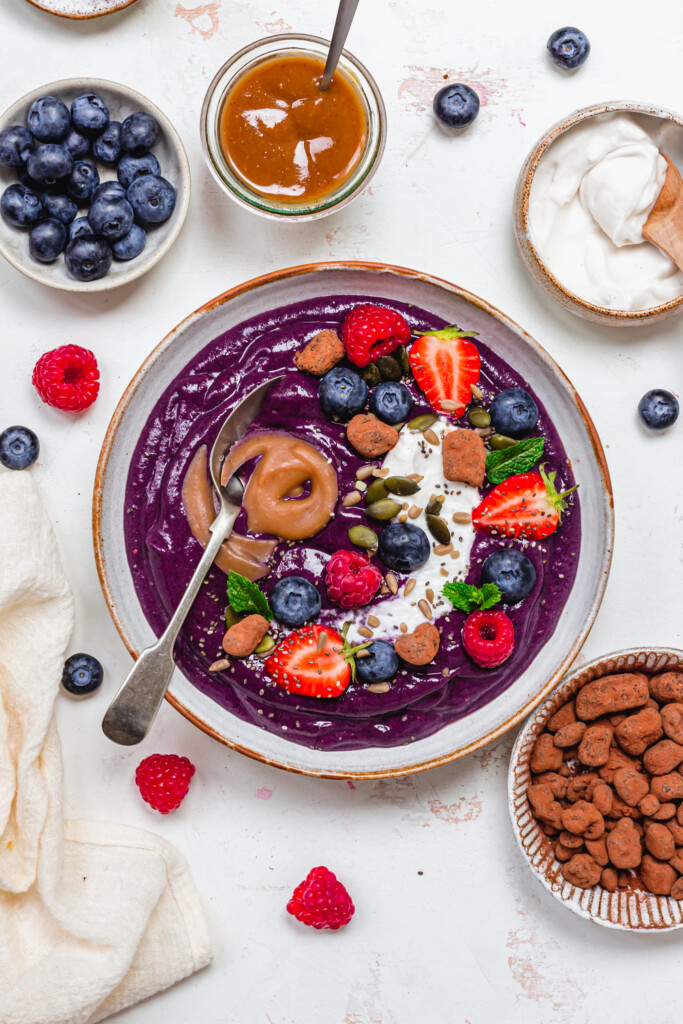 A spoon in a Blueberry Caramel Smoothie Bowl
