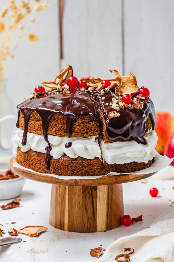 A Chai Apple Cake with Chocolate Ganache on a wooden cake stand