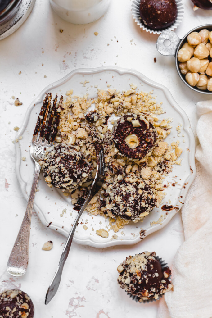 Ferrero Rocher Protein Balls on a plate of crushed hazelnuts