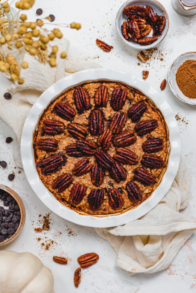 Pecan Pie Chocolate Chip Baked Oats in a dish with a white cloth