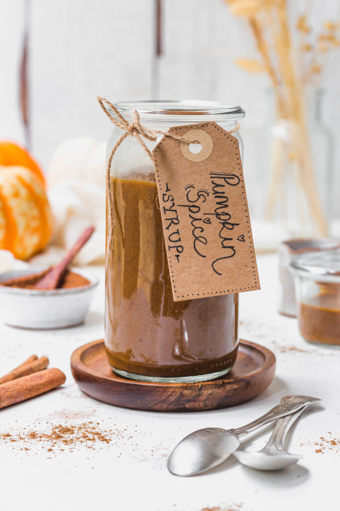 A jar of Pumpkin Spice Latter Syrup with a tag