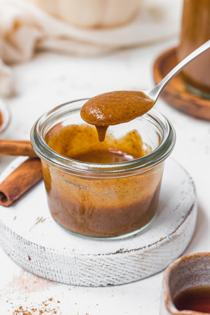 A spoon of Pumpkin Spice Syrup and small jar