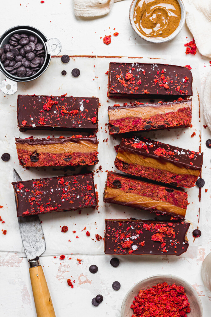 8 Chocolate Caramel Red Velvet Cake Bars on a board with a knife