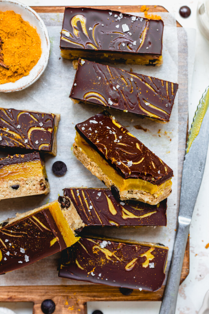 Golden Tahini Caramel Bars on a board with a knife