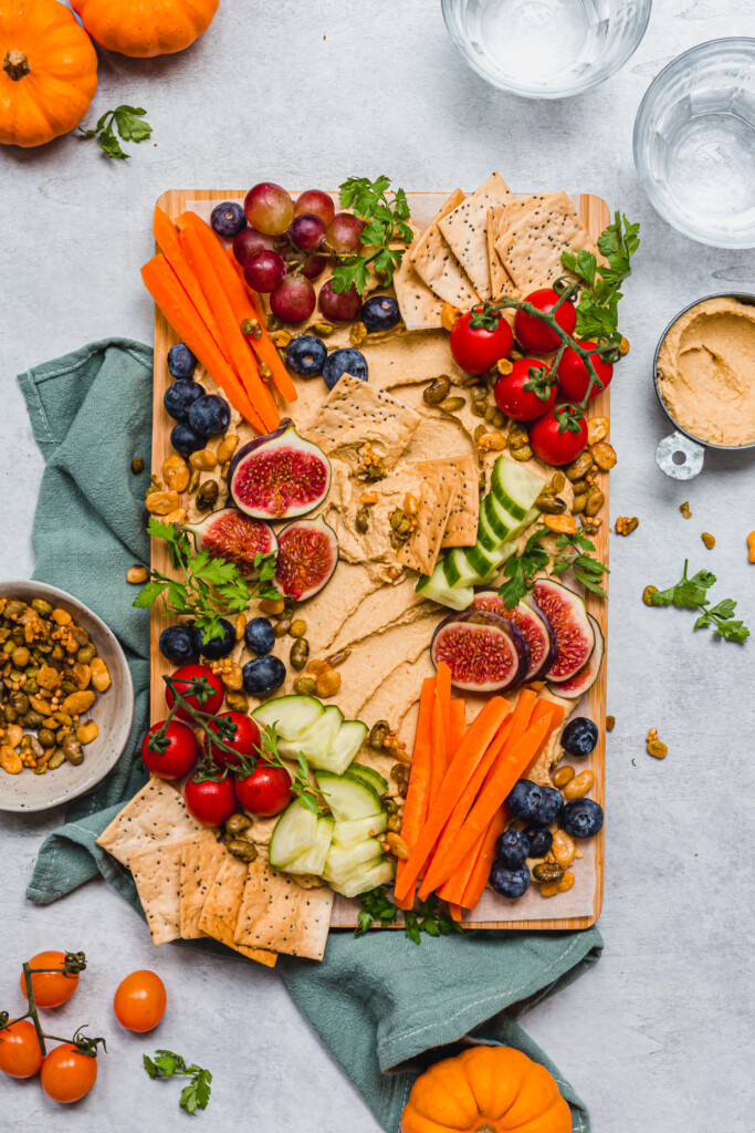 Crackers dipped into a Sweet Chilli Pumpkin Hummus Board