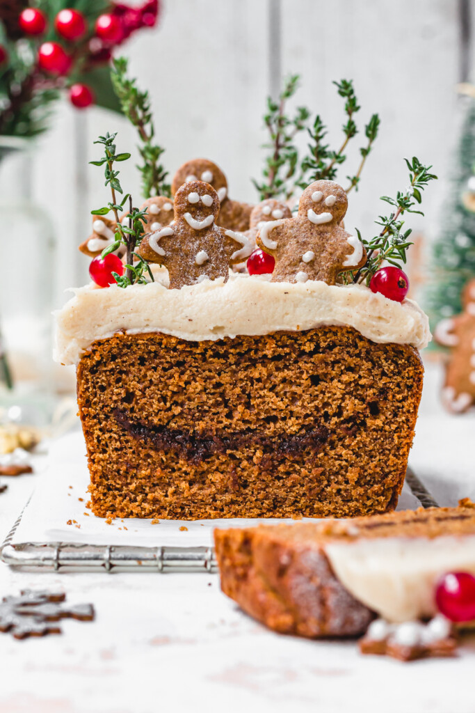 A Vegan Gingerbread Loaf with Cream Cheese Frosting with a slice removed