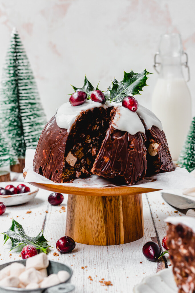 A slice of Chocolate Christmas Pudding Bomb leaning on a cake stand