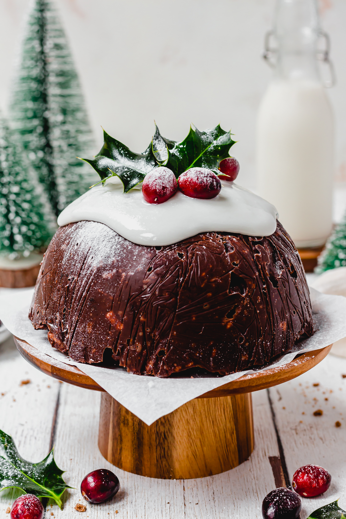 Chocolate Christmas Pudding Bomb on a wooden cake stand