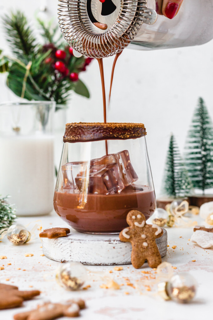 Pouring a Chocolate Gingerbread Mocktail into a glass with ice