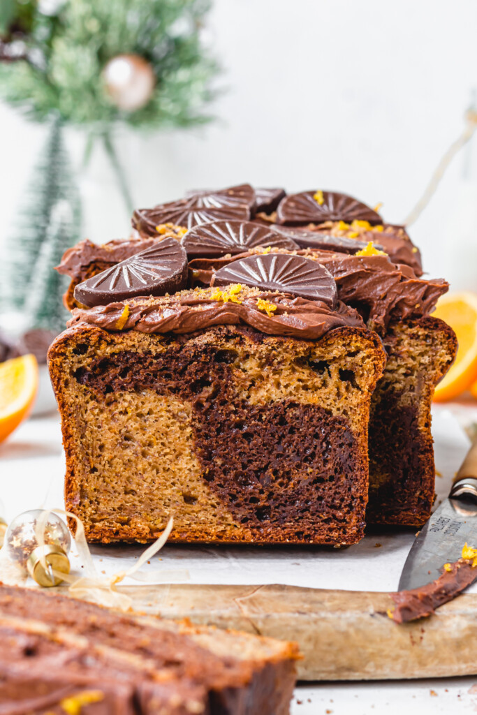 A loaf of Vegan Chocolate Orange Banana Bread with a knife and bauble