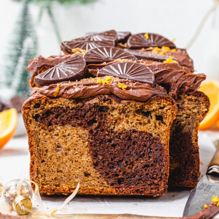 A loaf of Vegan Chocolate Orange Banana Bread with a knife and bauble