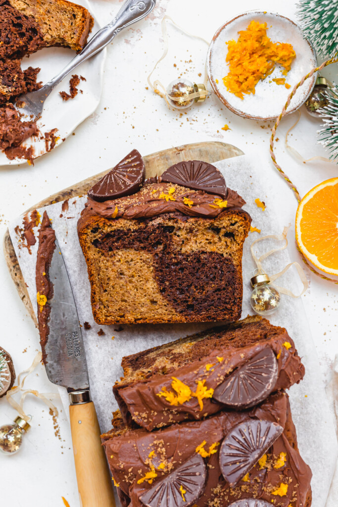 Vegan Chocolate Orange Banana Bread on a wooden board with a slice face up