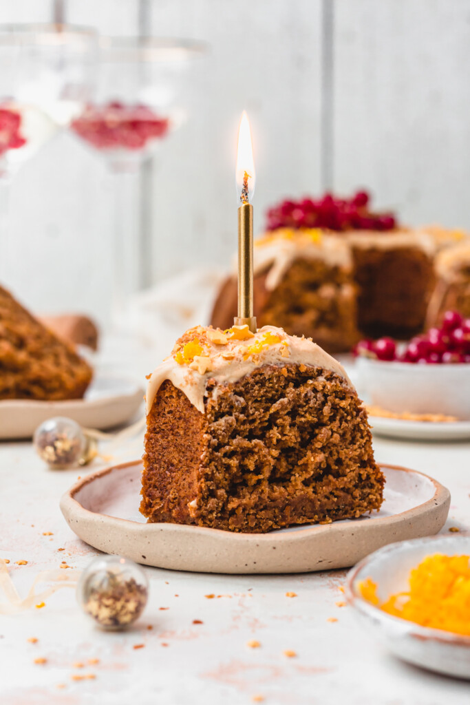 A candle on a slice of Vegan Orange Champagne Bunt Cake