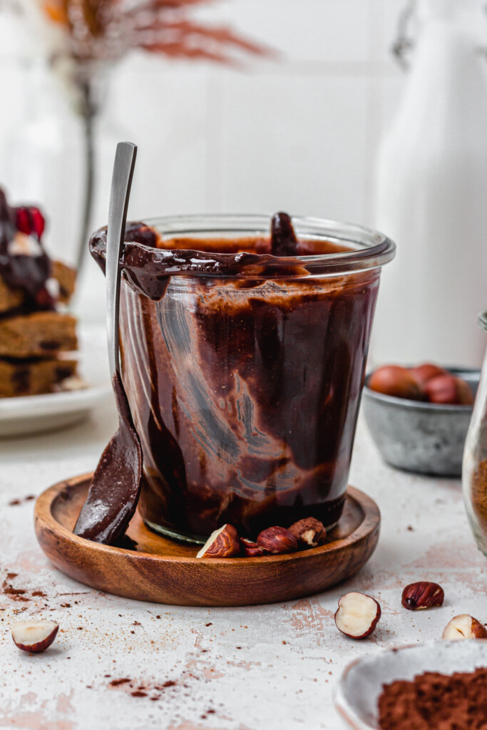 A spoon leaning against a jar of Homemade Vegan Nutella