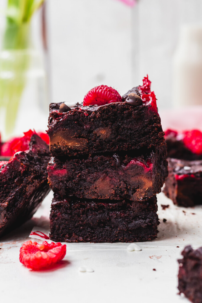 A stack of three Red Velvet Cheesecake Brownies with one leaning against them