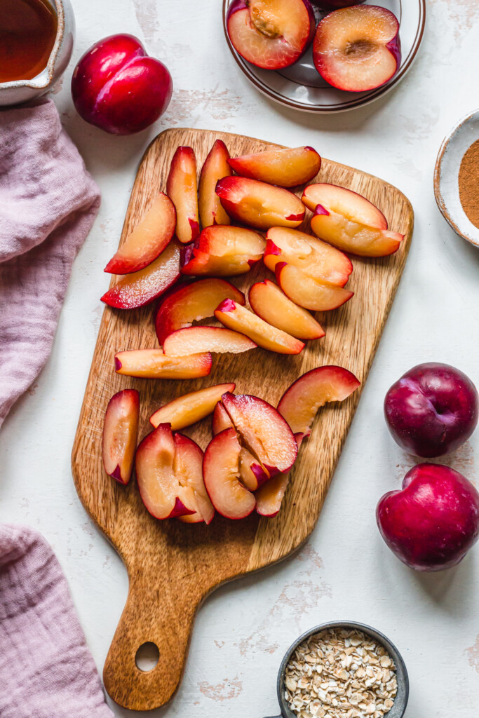 Sliced plums on a wooden chopping board