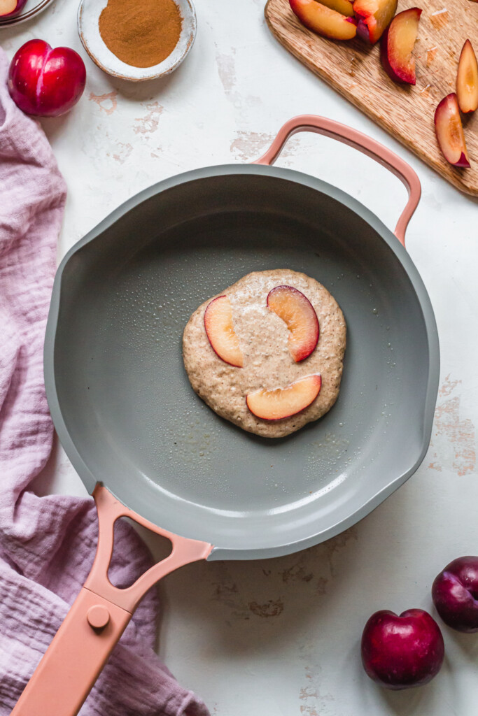 Frying off a plum pancake in a pink pan