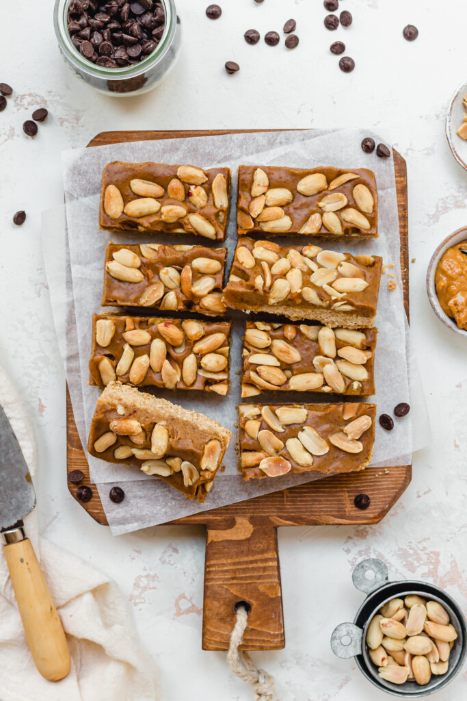 Eight peanut butter caramel bars on a wooden board