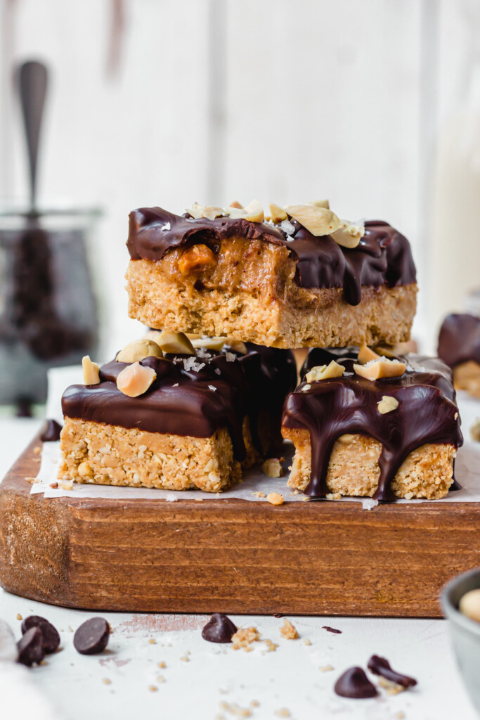A stack of three Vegan Protein Snickers on a wooden board