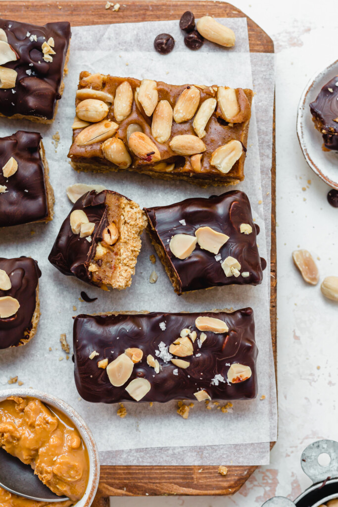 A cut up Vegan Protein Snickers on a wooden board with other abrs