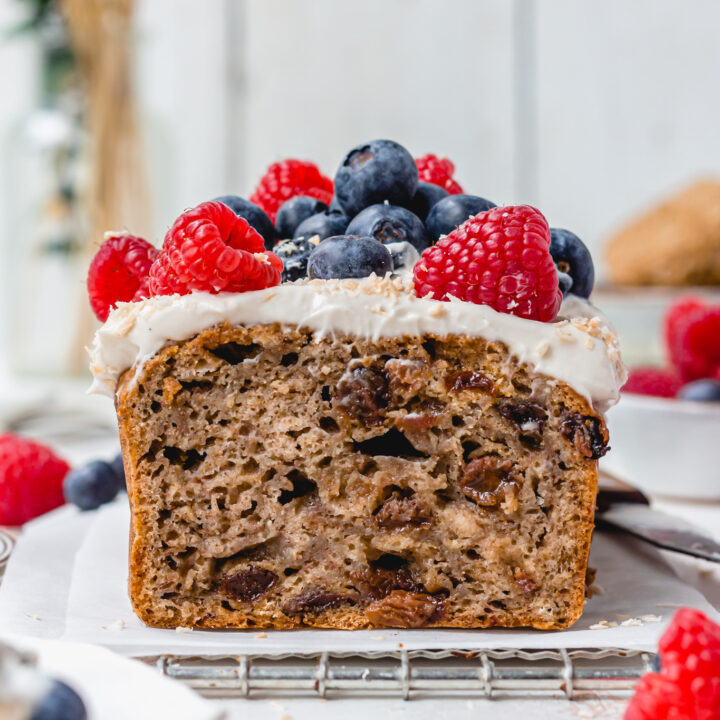 A loaf of Vegan Weetabix Cake with berries on top