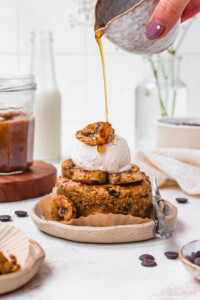 Pouring maple syrup over a Chocolate Chip Salted Caramel Cookie Skillet with ice cream