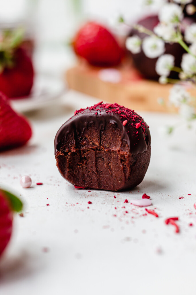 One Chocolate Strawberry Truffles with flowers in the background