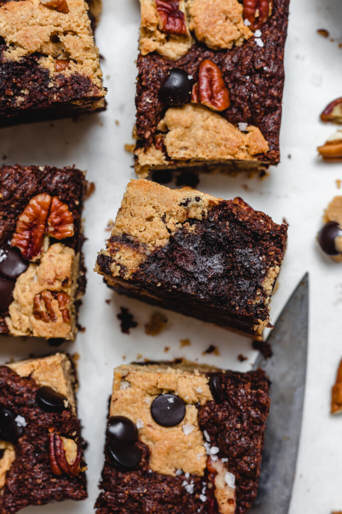 Close up of one piece of Pecan Brownie Cookie Dough Bar surrounded by other bars