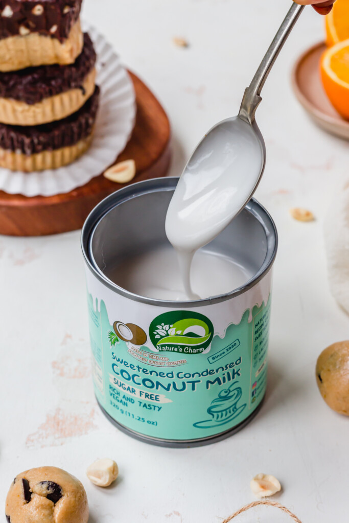 A tin of Sugar-free Sweetened Condensed Coconut Milk from Natures Charm with a spoon